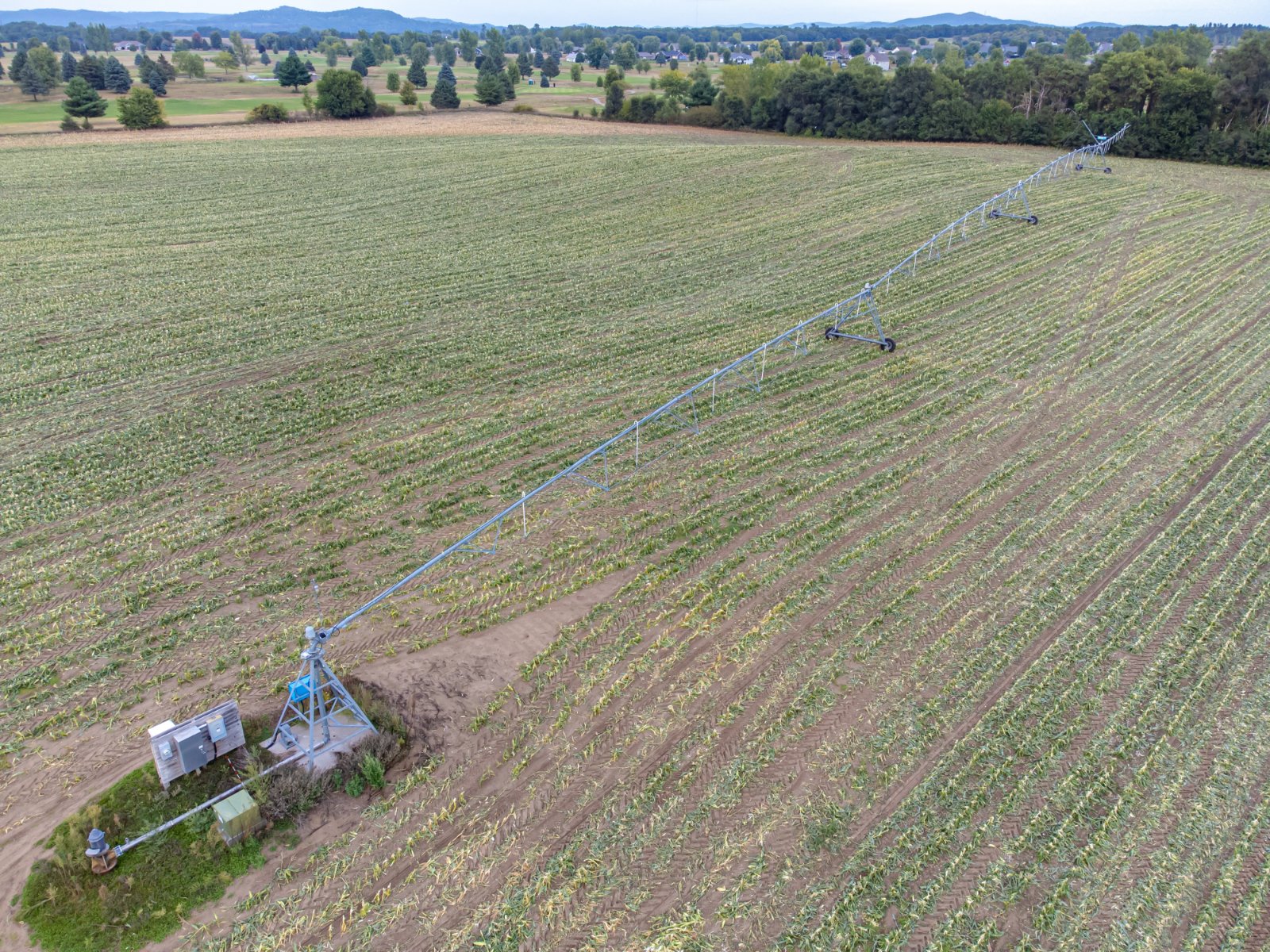 An irrigation system extending diagonally across a cultivated field. Illustrative photograph.